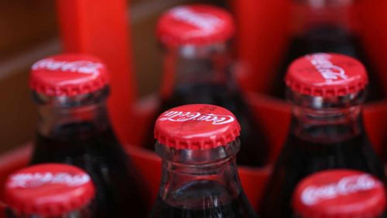 Multiple glass bottles of coca-cola beverage