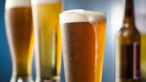 a close up of a bottle and a glass of beer on a table