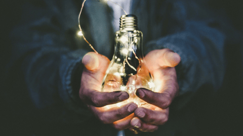 two hands holding a light bulb