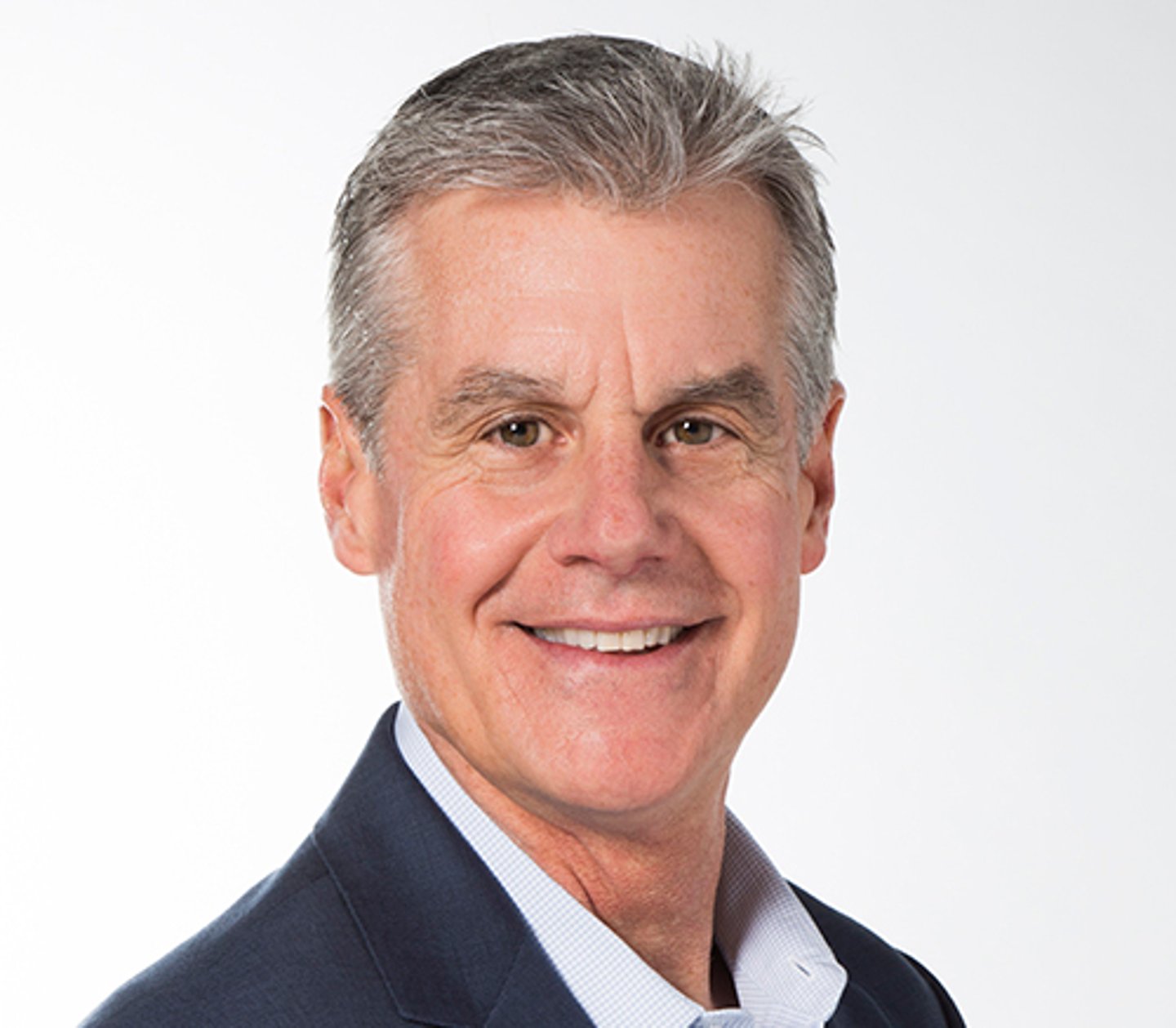 a man wearing a suit and tie smiling at the camera