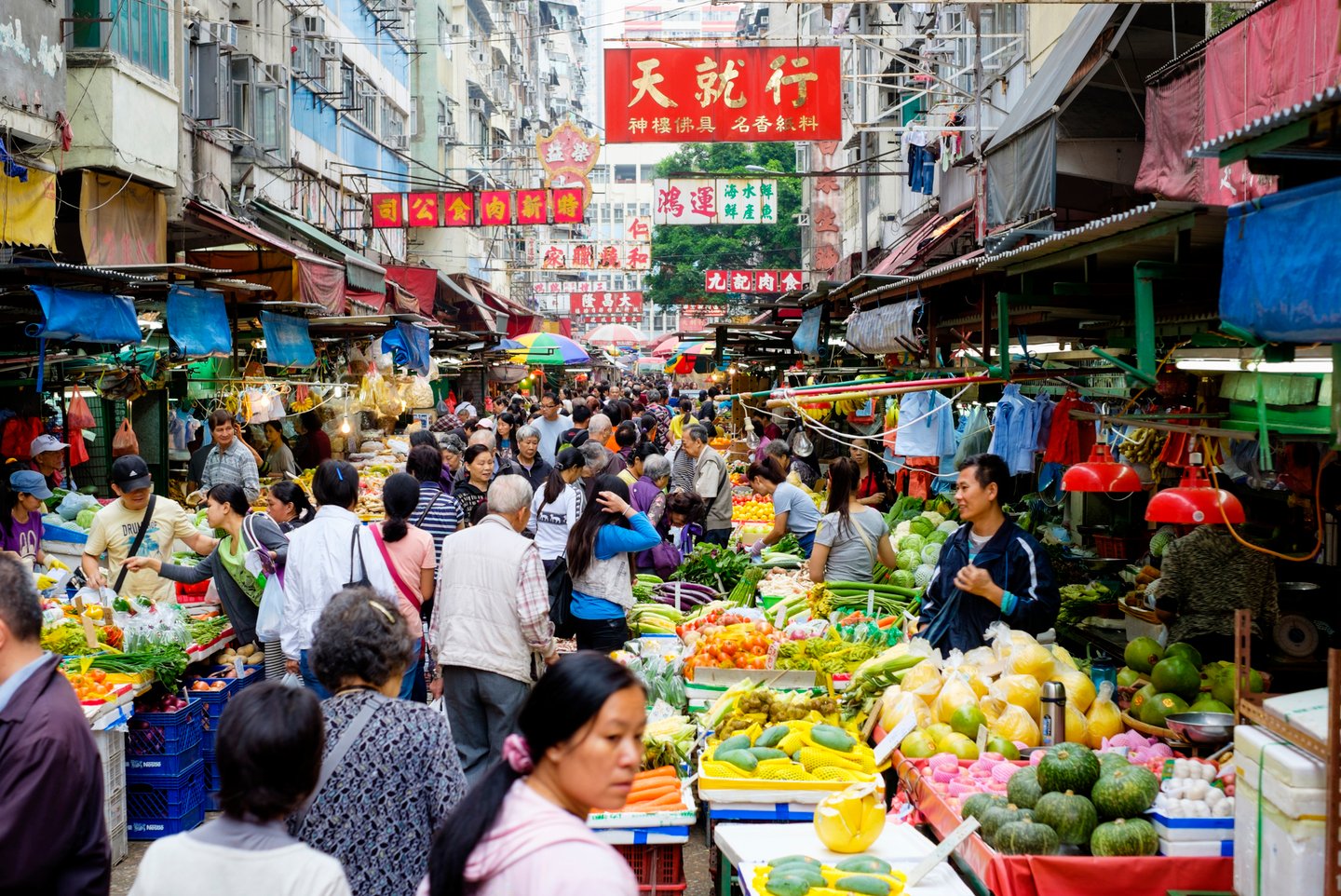 a crowd of people at a fruit stand