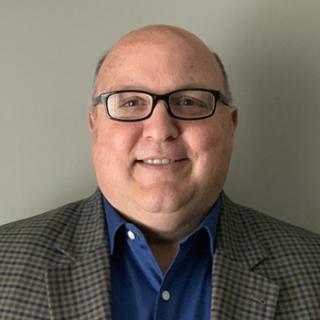 a man wearing glasses posing for the camera