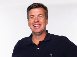 a man who is smiling and looking at the camera