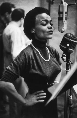 Eartha Kitt singing into a microphone
