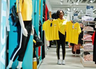 woman holding up two shirts in a store