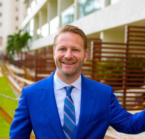 a man wearing a suit and tie smiling at the camera