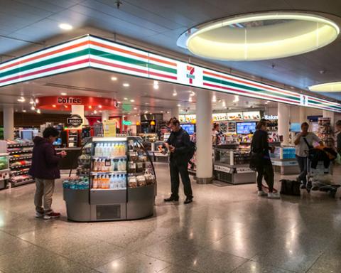 a group of people standing around a luggage carousel at an airport