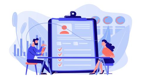 Two people interviewing in front of a checklist