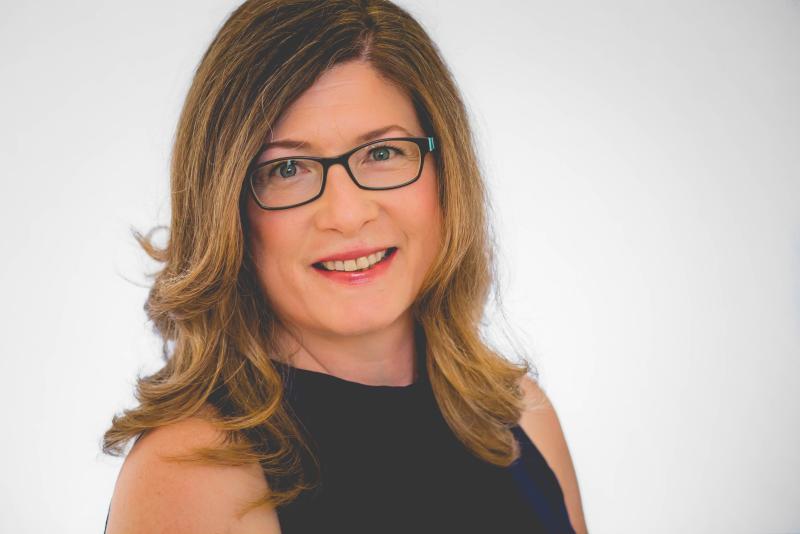 Mary Rodgers wearing glasses and smiling at the camera